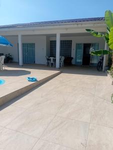 una casa con un patio con mesa y sillas en Casa em Guaratuba com piscina, en Guaratuba