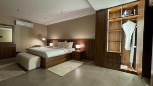 Al ‘AynJA Accom的一间卧室,配有一张床,窗户上挂着一连串连衣裙