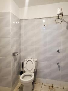 a bathroom with a white toilet in a stall at Royal Nest in Rungiri