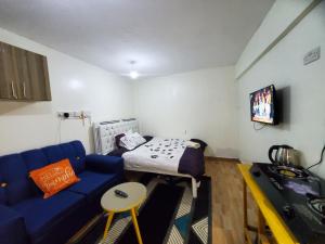 a living room with a blue couch and a bed at Royal Nest in Rungiri