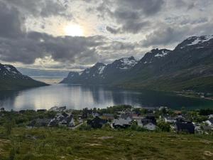 a town on the shore of a lake with mountains at Ersfjord Villa Apt in Tromsø