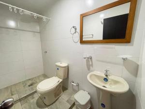 um banheiro com vaso sanitário, pia e espelho em Confortable Hospedaje- Ubicación Estratégica Bogotá em Bogotá