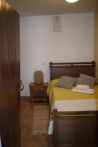a bedroom with a bed with yellow sheets and a night stand at Casa do Chico in Mértola