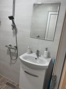 a white bathroom with a sink and a mirror at White House Apartments - Studio Lux in Haskovo