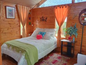 a bedroom with a bed with a red ball on it at Cabaña Los Linos in Guasca