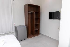 a bedroom with a book shelf and a television at Arkan Hotel Qena in Qinā