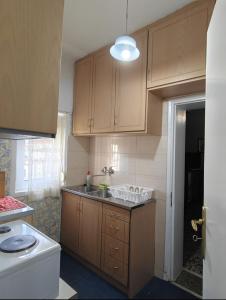 a kitchen with wooden cabinets and a sink at Grandmas Mansion 3BD Meteora - Rocks View in Kalabaka
