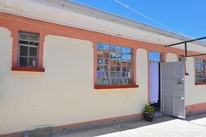 an orange and white building with a door and windows at Two Bedroom Free Wi-Fi and Netflix in Nanyuki on your way to Ol Pejeta Conservancy in Nanyuki