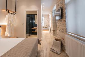 a bedroom with a bed and a wall with a window at Nest in the City Studio Volos in Volos