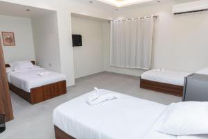 a hotel room with two beds and a television at Arkan Hotel Qena in Qena