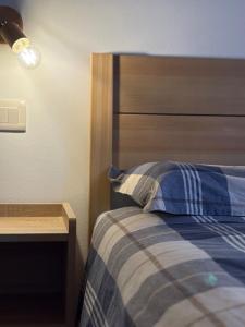 a bedroom with a bed with a wooden headboard at Casa Sofia Panoramic View and Private Box in Temù