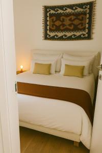a bedroom with a bed with white sheets and yellow pillows at Suite 21 Eleganza e Comfort in Torino in Turin +6 photos