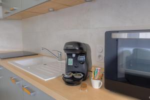 a coffee maker sitting on a kitchen counter next to a microwave at Parenthèse rambertoise in Saint-Rambert-dʼAlbon