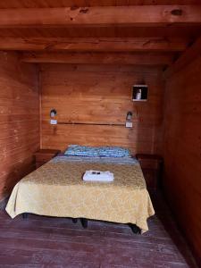 a bedroom with a bed in a wooden room at El Parador in Paso de la Patria