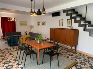 a room with a table and chairs and a staircase at Gîte du Château avec Piscine Intérieure in Ligny-le-Châtel