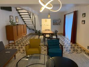 a room with a table and chairs and a staircase at Gîte du Château avec Piscine Intérieure in Ligny-le-Châtel +15 photos