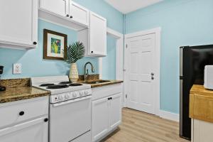 a kitchen with white appliances and blue walls at Parrot Beach Cottages Suite #1 in Bailey Hall