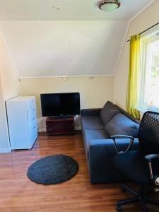 een woonkamer met een bank en een flatscreen-tv bij Koselig hus i Svolvær i Lofoten med elbil-lader in Svolvær