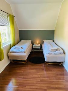 twee bedden in een kleine kamer met een tafel bij Koselig hus i Svolvær i Lofoten med elbil-lader in Svolvær
