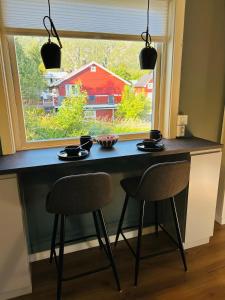 een tafel en twee stoelen voor een raam bij Koselig hus i Svolvær i Lofoten med elbil-lader in Svolvær