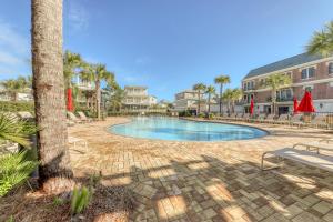 a swimming pool with chairs and a palm tree at Village of South Walton EB211 in Rosemary Beach