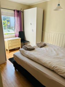 een slaapkamer met een bed, een stoel en een raam bij Koselig hus i Svolvær i Lofoten med elbil-lader in Svolvær