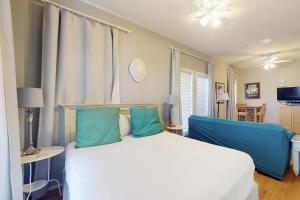 a bedroom with a white bed and blue pillows at Village of South Walton EB211 in Rosemary Beach +22 photos