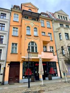トルンにあるBelvedere Old Town AC Progresの傘2本前のオレンジ色の建物