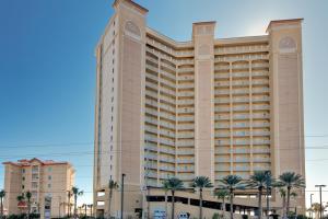 a large building with palm trees in front of it at Seawind 1503 in Gulf Shores