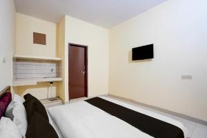 a bedroom with a bed and a tv on the wall at Hotel O Deepak Hotel in Gurgaon +21 photos