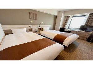 a hotel room with two beds and a television at Smile Hotel Premium Hakodate Goryokaku - Vacation STAY 97566v in Hakodate +39 photos
