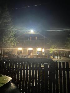 a building at night with a fence in front of it at cabana mija in Jieţ
