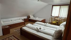 a room with three beds and a table and a table at cabana mija in Jieţ