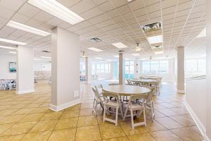 Una gran sala con mesas, sillas y ventanas. en Islander W 306, en Fort Walton Beach