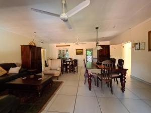 a living room with a ceiling fan and a table at DuneSide Guesthouse in Richards Bay