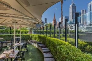 a restaurant with tables and chairs and a view of the city at Quay West Suites Melbourne in Melbourne