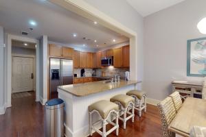 a kitchen with a large island with bar stools at Redfish Village M1-220 in Blue Mountain Beach