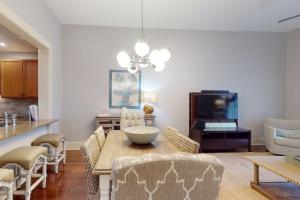 a living room with a table with chairs and a television at Redfish Village M1-220 in Blue Mountain Beach