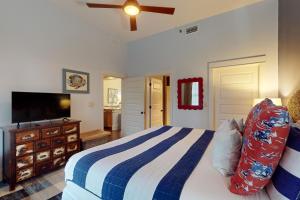 a bedroom with a bed and a flat screen tv at Redfish Village M1-220 in Blue Mountain Beach +15 photos