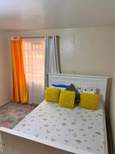 un letto con cuscini colorati sopra di Blissful haven Stays a Ruaka Altre 3 foto