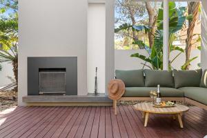 Una sala de estar con un sofá y una chimenea. en Beachside Bungalow on Shelly Beach, en Caloundra