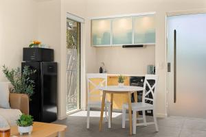 eine kleine Küche mit Tisch und Kühlschrank in der Unterkunft Beachside Bungalow on Shelly Beach in Caloundra