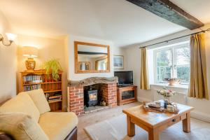 a living room with a couch and a fireplace at Watts Cottage in Upton