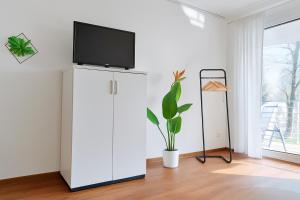 a living room with a tv on top of a white cabinet at Studioappartment mit Balkon in Langenau