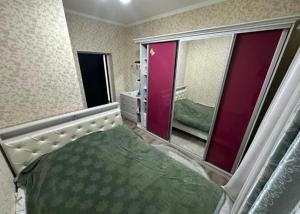 a bedroom with a bed and a large mirror at Частный дом в Бишкеке in Bishkek