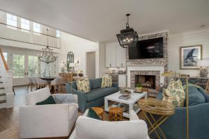 - un salon avec des canapés bleus et une cheminée dans l'établissement Lowcountry Luxe by The Tides- Pool & Porch, à St. Helena Island