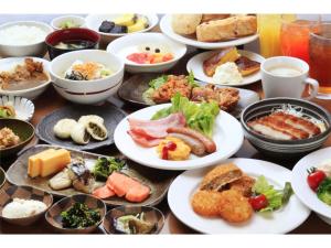 東京にあるSmile Hotel Tokyo Shinkoiwa - Vacation STAY 33623vのテーブルの上にたくさんの食べ物の皿が置かれている