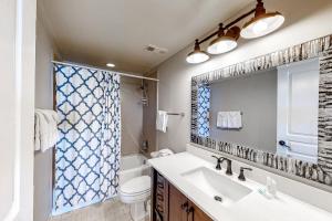 a bathroom with a sink and a toilet and a mirror at Silver Beach 704 in Romar Beach +16 photos