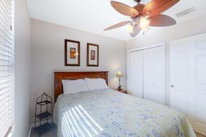 a bedroom with a bed with a ceiling fan at Grand Caribbean 121 in Orange Beach +23 photos