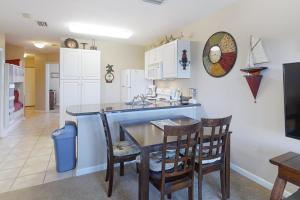 a kitchen and dining room with a table and chairs at Grand Caribbean 121 in Orange Beach